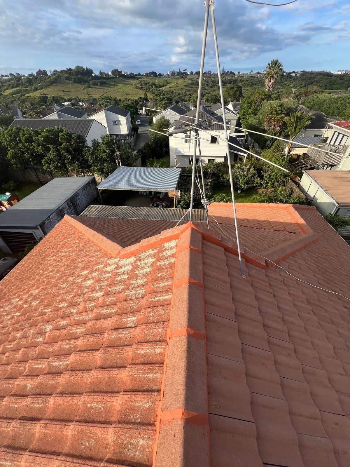 Auckland tile roof after respray — clean dark grey finish across the full roof with suburb backdrop