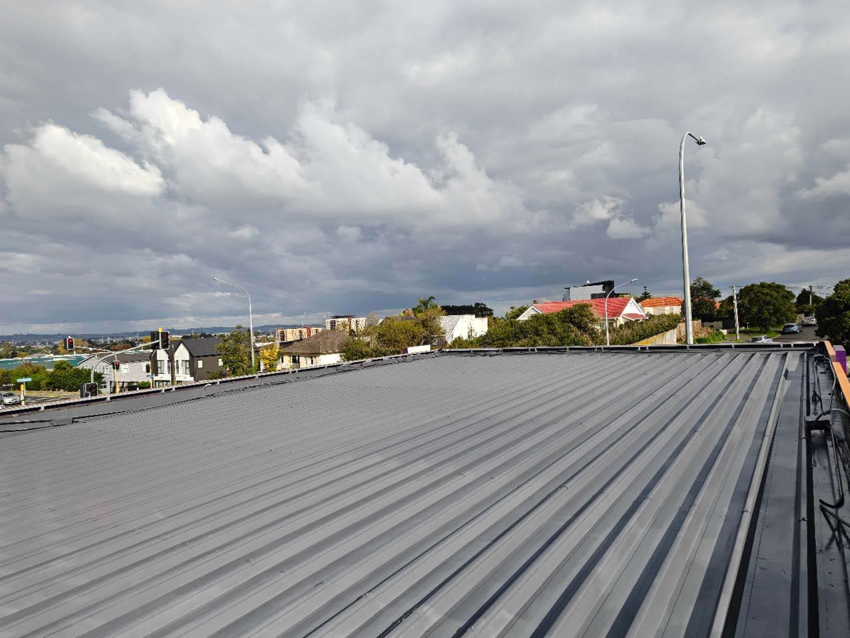 Large commercial corrugated iron roof freshly resprayed in dark grey — Auckland CBD